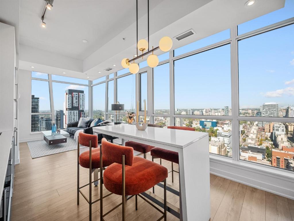 a kitchen and living room with large windows at VOGUE Suites Toronto in Toronto
