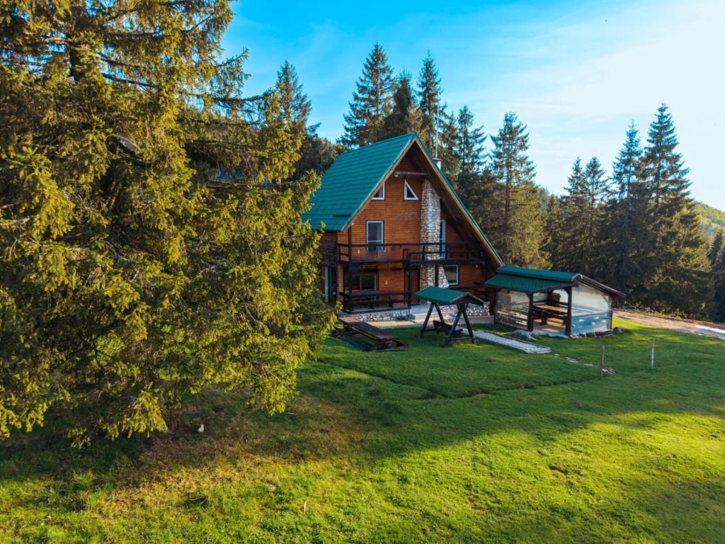 an aerial view of a log cabin with a playground at Pensiunea HEIDI in Vartop