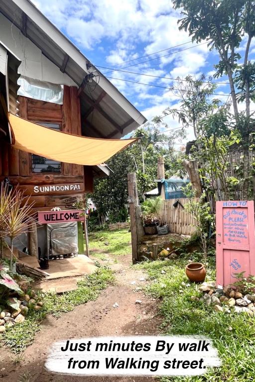 a building with a yellow umbrella next to a walking street at Sun Moon Pai Bungalow in Pai