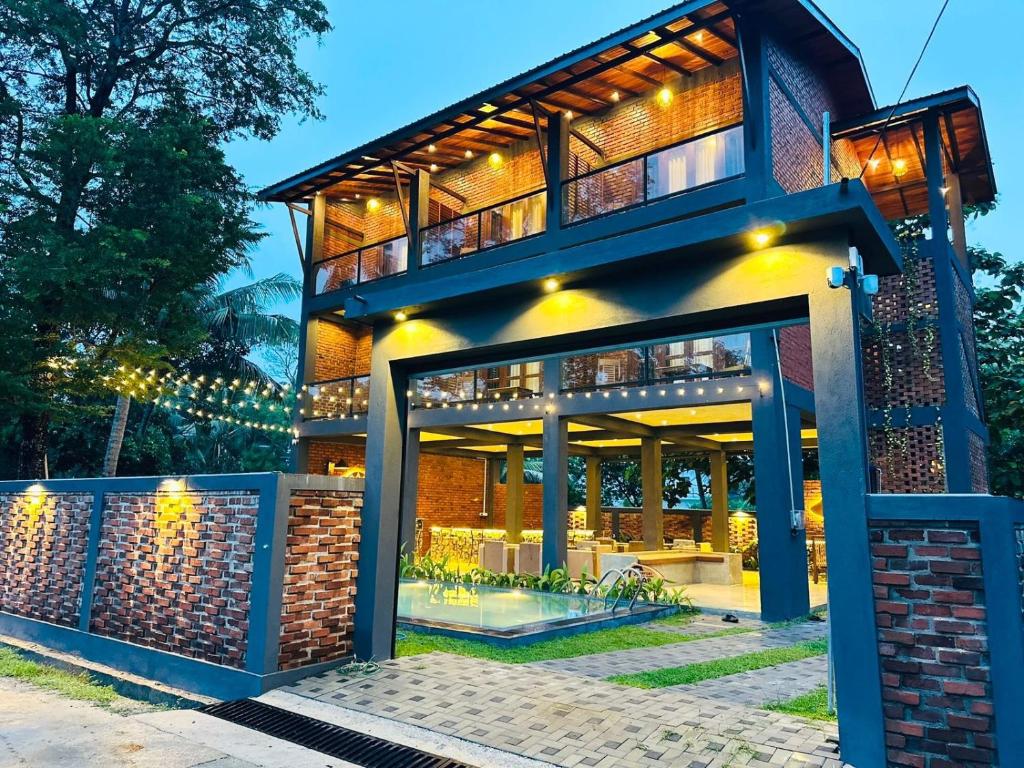 a house with a lit up facade at night at Airport Hotel Transit 98 in Katunayaka