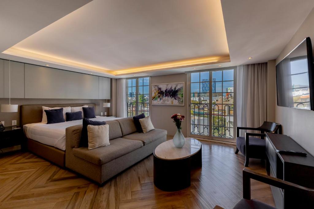 a large living room with a couch and a piano at Isaaya Hotel Boutique by WTC in Mexico City