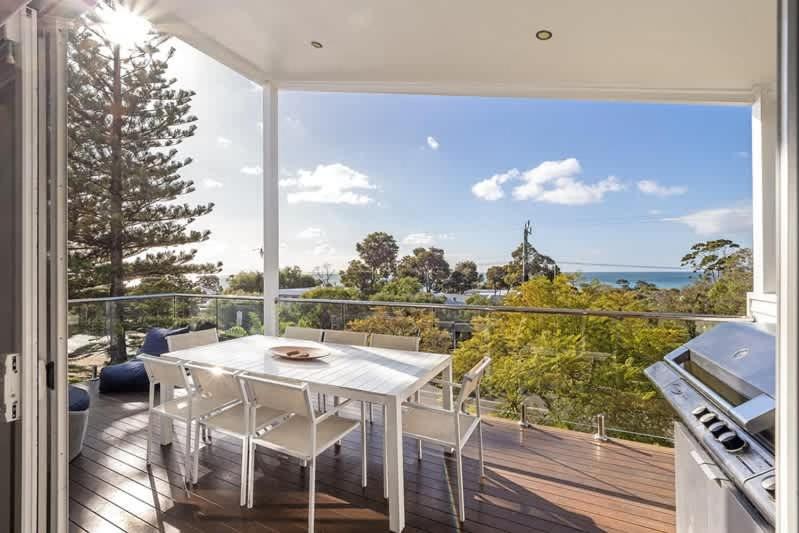 a dining room with a white table and a view of the ocean at Casa Bianca - Oceanview Beachside Escape in Dunsborough