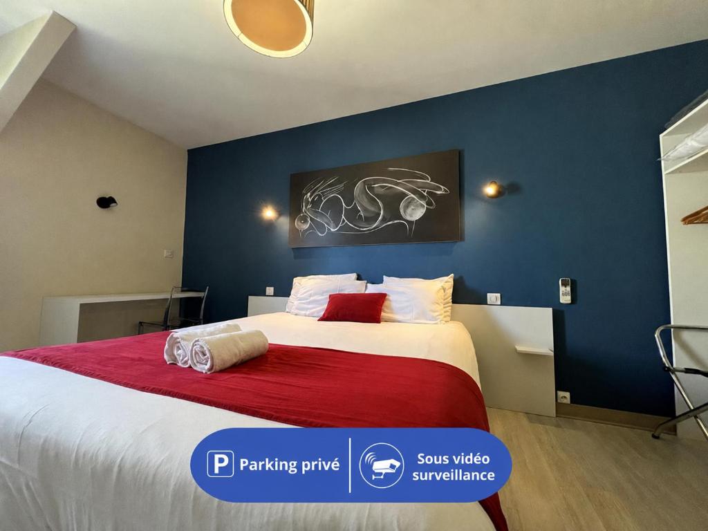 a bedroom with a large bed with a red blanket at Brit Hotel du Parc Niort Centre-Parking gratuit in Niort