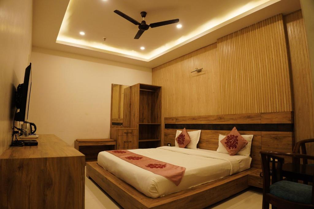 a bedroom with a bed with a ceiling fan at Hotel Parth Inn in Haldwāni