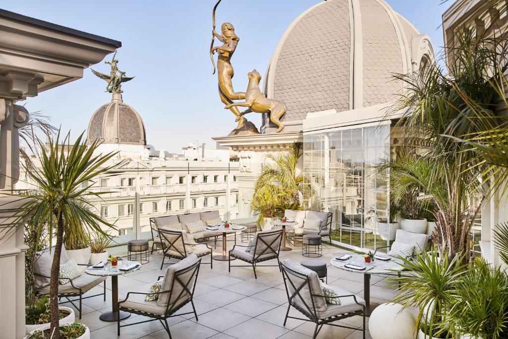 a patio with tables and chairs on top of a building at Hyatt Centric Gran Via Madrid in Madrid