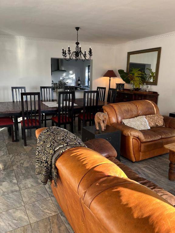 a living room with a couch and a dining room at Private Retreat in Gordonʼs Bay