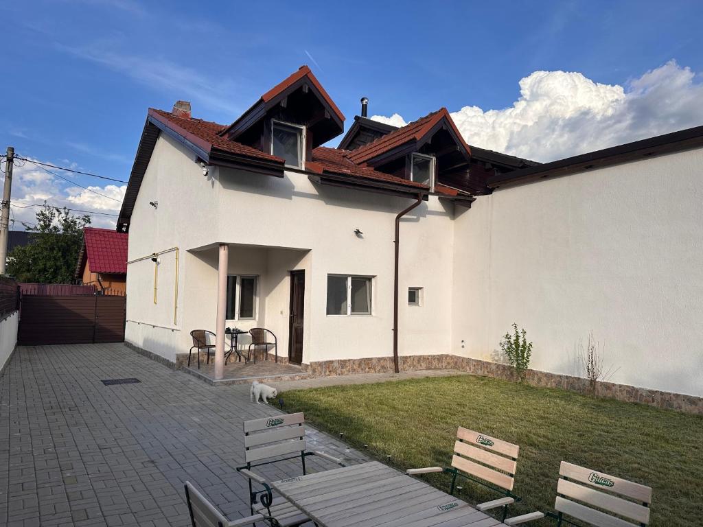 a white house with a picnic table and chairs at Casa Happy in Petroşani