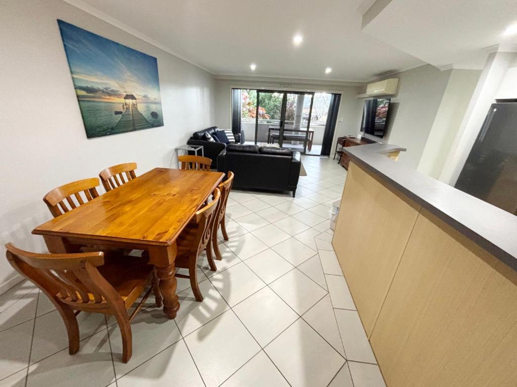 a living room with a wooden table and chairs at Jubilee Apartment 08 - Bring your own linen in South West Rocks