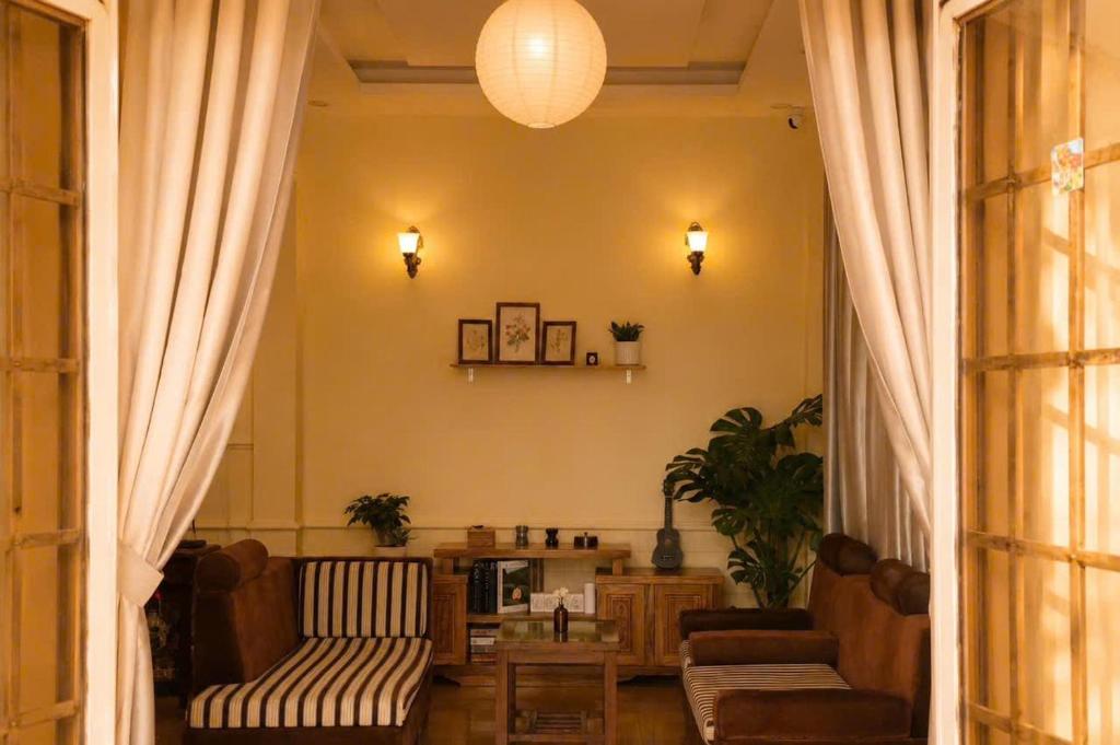a living room with a couch and a table at Thềm Homestay in Da Thien