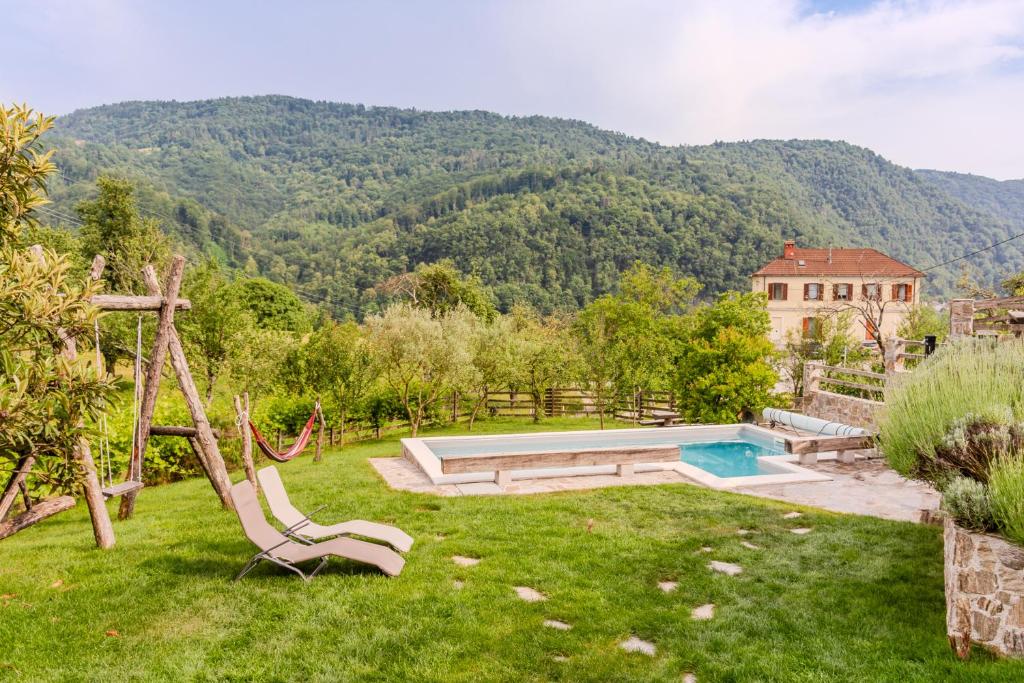 a backyard with a swimming pool and a house at Farmhouse Cvetje in Tolmin