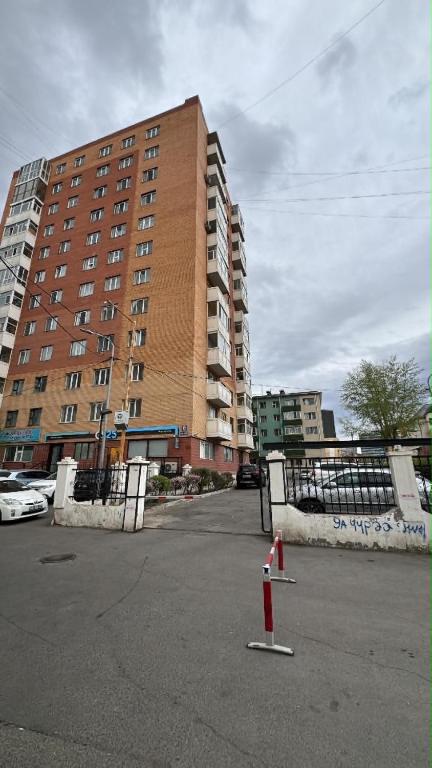 a tall building in a parking lot with a red cone at Near ASA Arena Circus in Ulaanbaatar