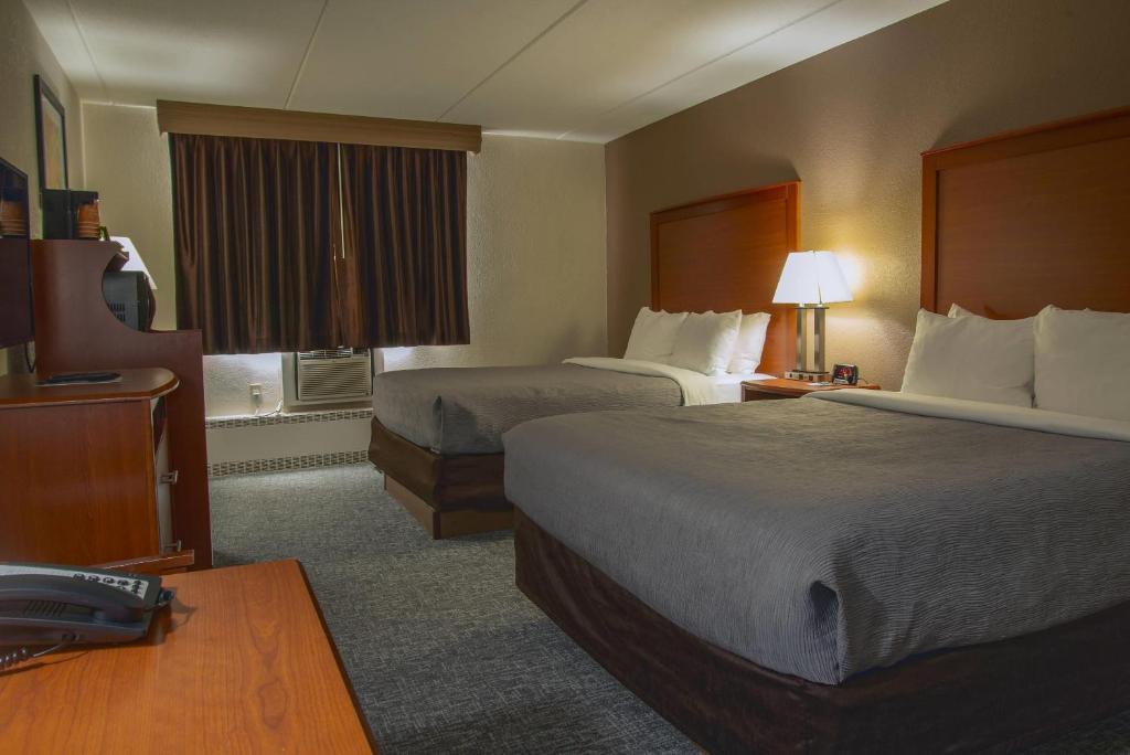 a hotel room with two beds and a desk at Quality Inn Stadium Area Green Bay Stadium in Green Bay