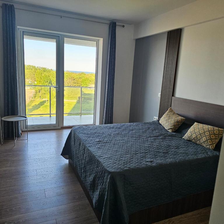 a bedroom with a bed and a large window at CHARLOTTE STUDIOS BY BLAXY RESORT Olimp in Olimp