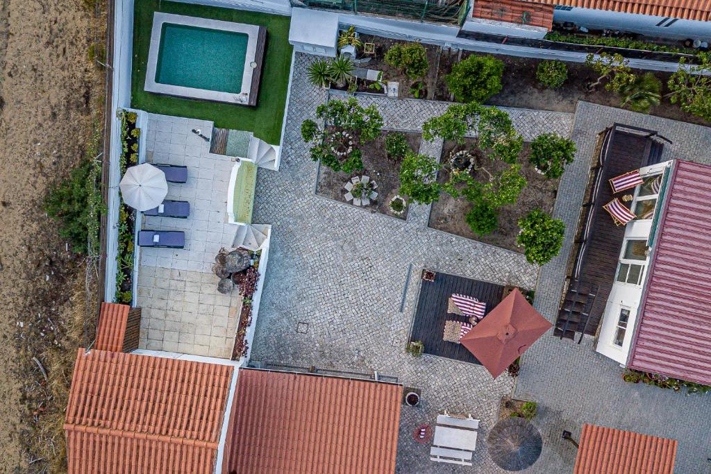 an overhead view of a patio with a table and an umbrella at Casa das Flores by Hostiva in Aroeira