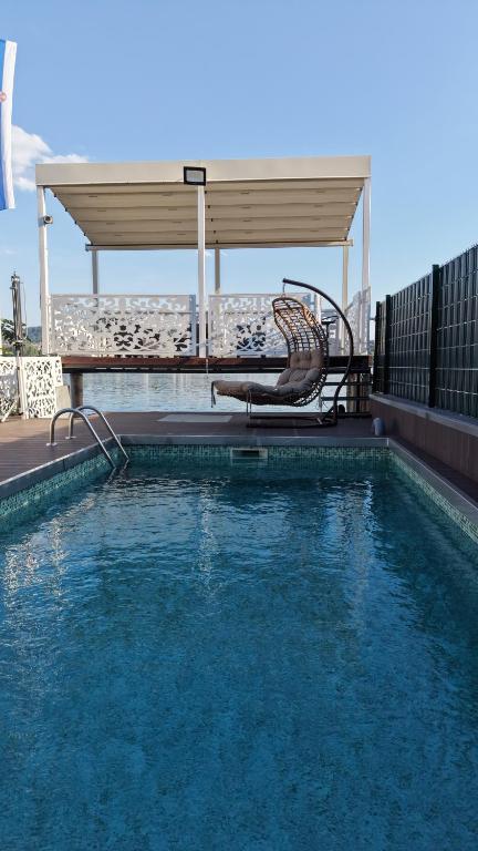 a swimming pool with a chair and a table and a chair at Belgrade River House in Belgrade