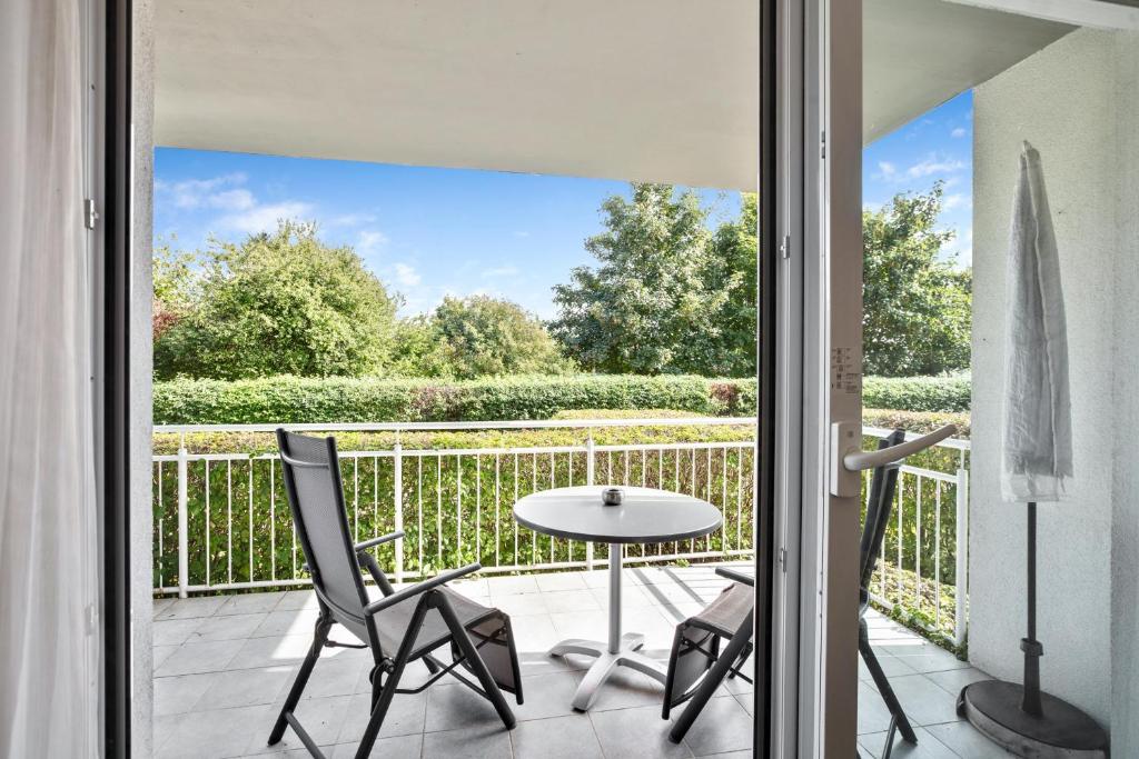 a patio with a table and chairs on a balcony at Ferienwohnung Landblick im Markgräflerland mit kostenlosem Parkplatz in Bad Bellingen