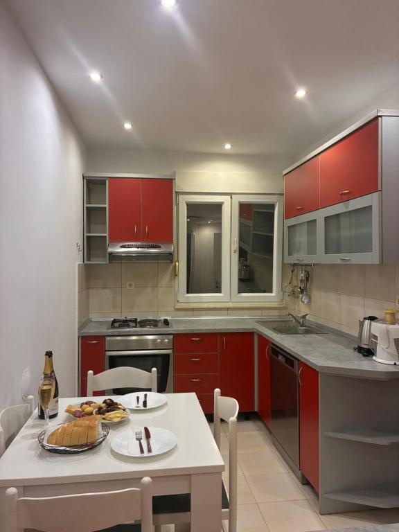a kitchen with red cabinets and a white table at Katarina in Kaštela