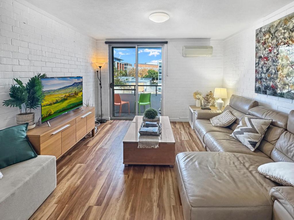 a living room with a couch and a tv at Location Location Vacation in Fremantle
