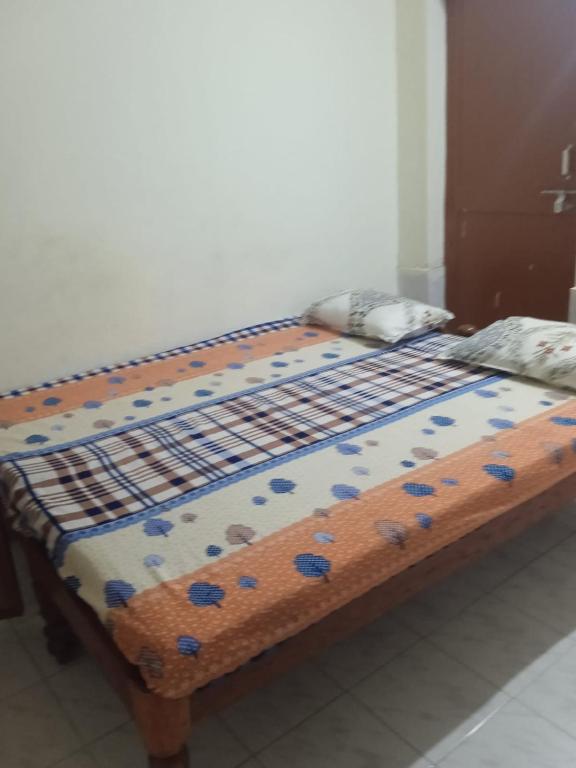 a bed with blue flowers on it in a room at Om Sai Manjunatha Residency in Puttaparthi
