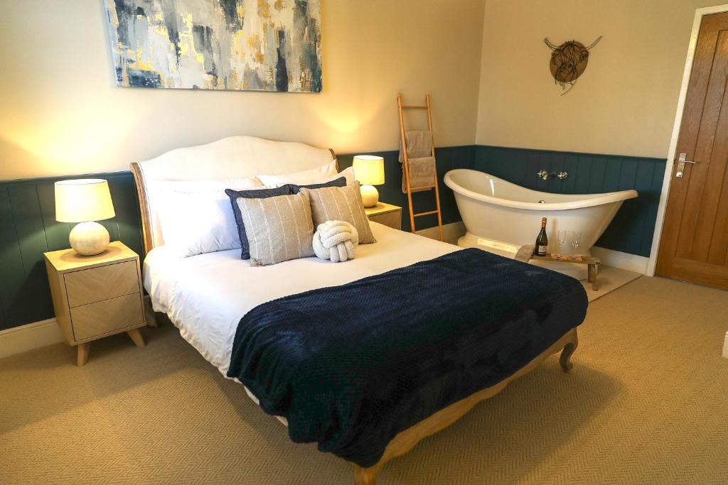 a bedroom with a bed and a bath tub at Windsor Cottage in Holmfirth