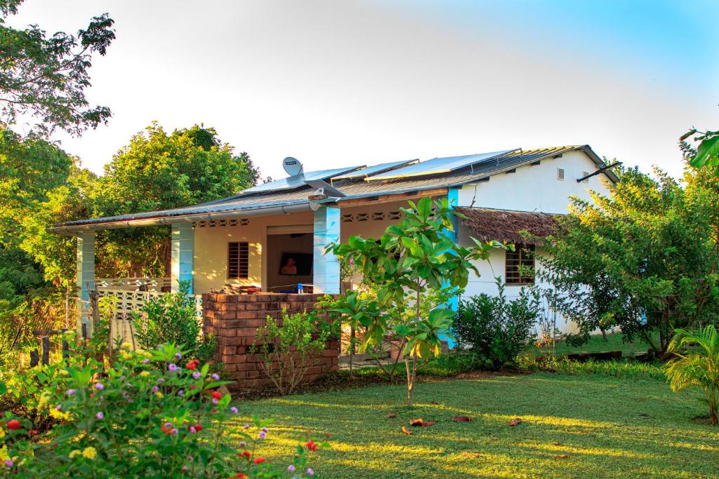 a small white house with a garden in front of it at Villa HARMONY in Andilana