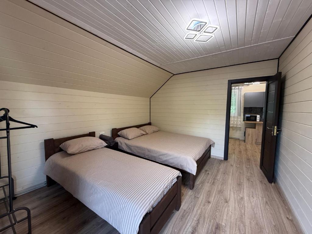two beds in a room with wood floors at Family House in Izki