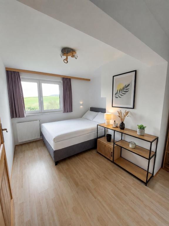 a bedroom with a bed and a table in it at Apartment Ledermoos - Ski, Langlauf & Wandern in Mauterndorf in Mauterndorf
