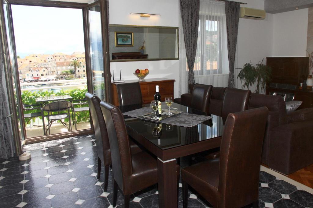 a dining room with a table and leather chairs at Apartments Romana in Postira