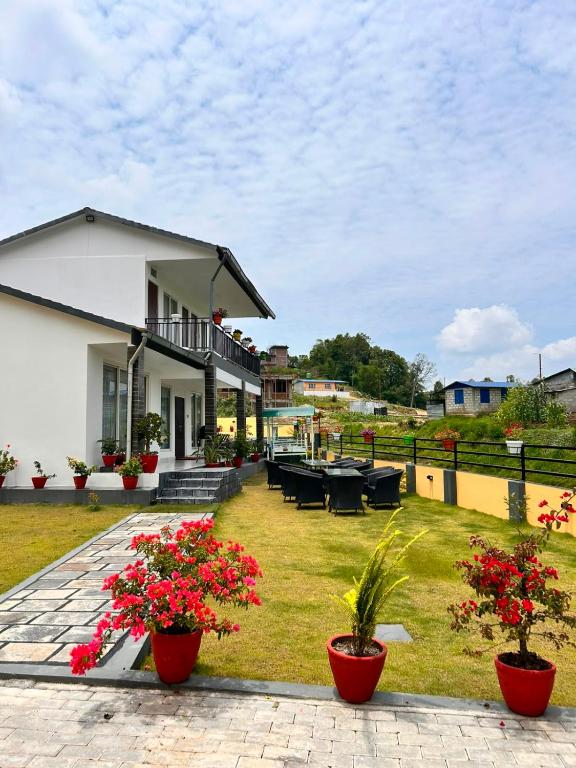 a house with red flowers in the yard at Aranya Villa in Bākhri Kharka