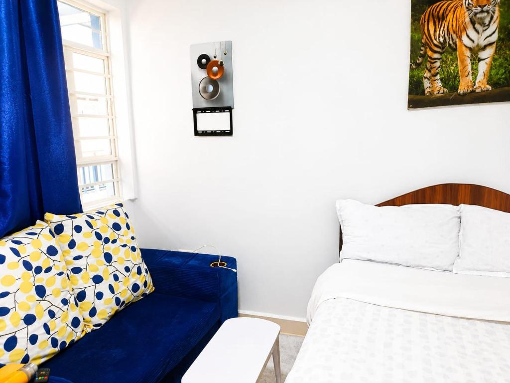 a bedroom with a bed and a blue couch at Annie's studio near Westside mall in Nakuru