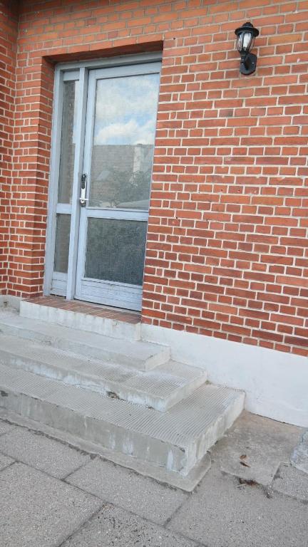 a door to a brick building with a window at Central located Large apartment on the 1st floor tv in Hjørring