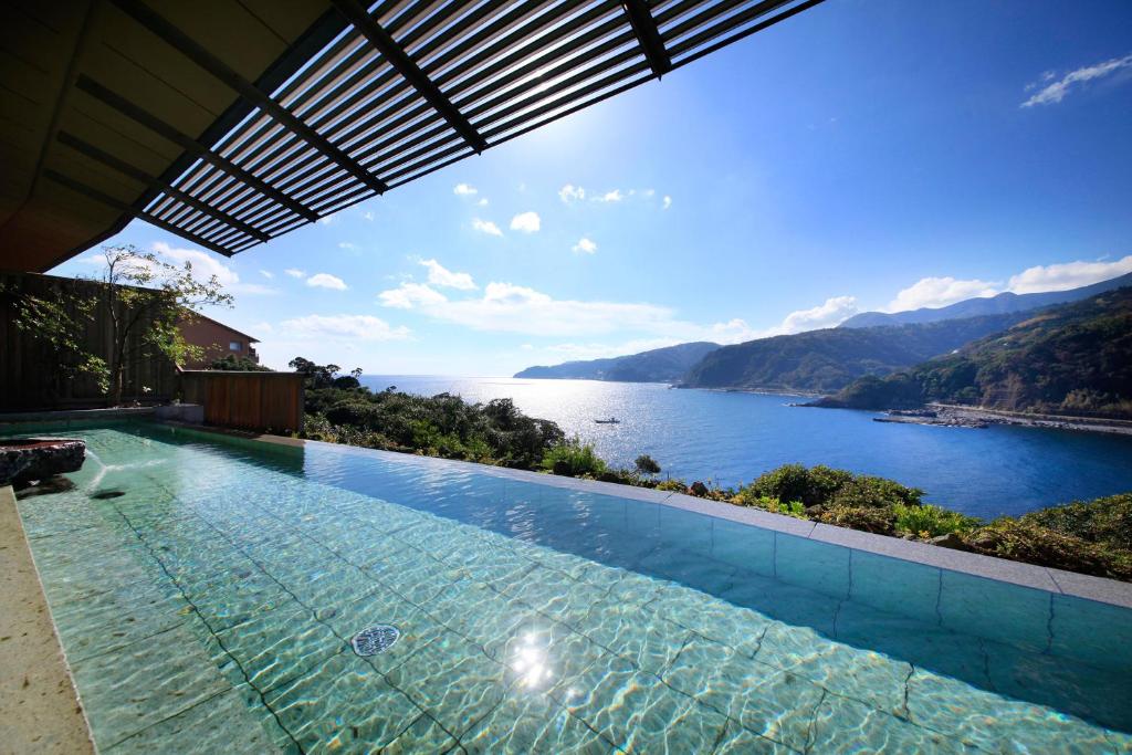 a swimming pool with a view of a body of water at Pleasure Resort Izu Akazawa Onsen in Ito