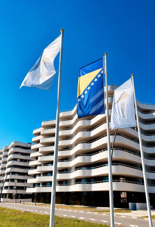 three flags in front of a building at Waves Hotel NEW IN 2026 in Sarajevo