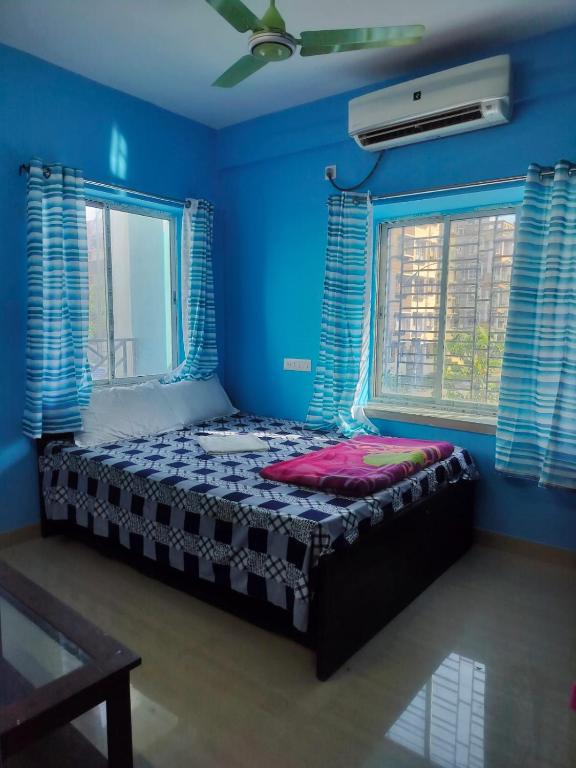 a bedroom with a bed in a blue room at Priya guest house in Howrah
