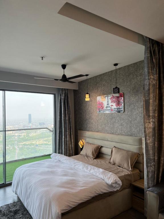 a bedroom with a large bed and a large window at Luxurystay-supernova in New Delhi