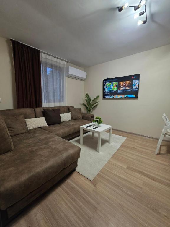 a living room with a couch and a tv at Charshiq Guest House in Veliko Tŭrnovo