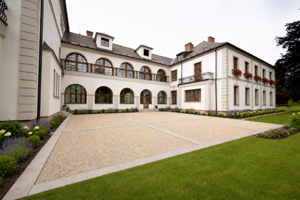 an exterior view of a large house with a lawn at Resort Červený dvůr - apartmány a wellness in Rapotín
