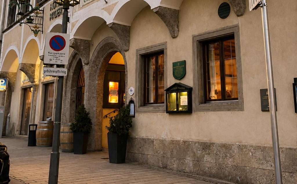 a building with arches and windows on a street at DORMERO MaHo Steyr in Steyr