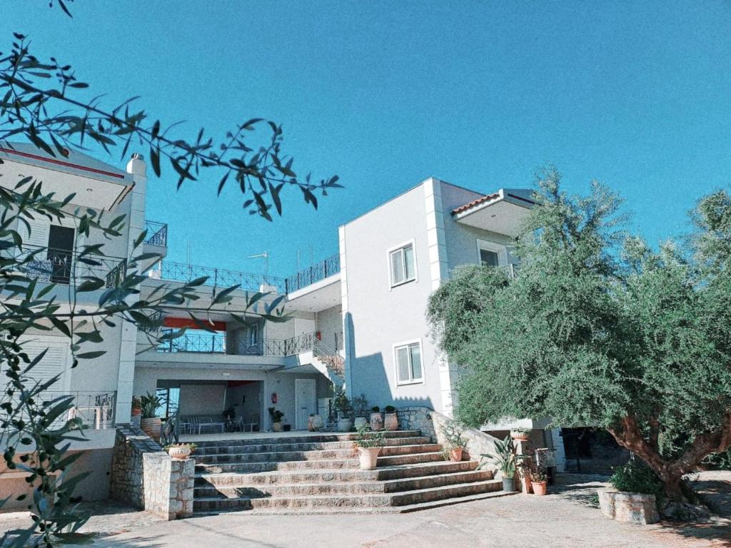 a white building with stairs in front of it at Areti & Maria Apartments in Gythio