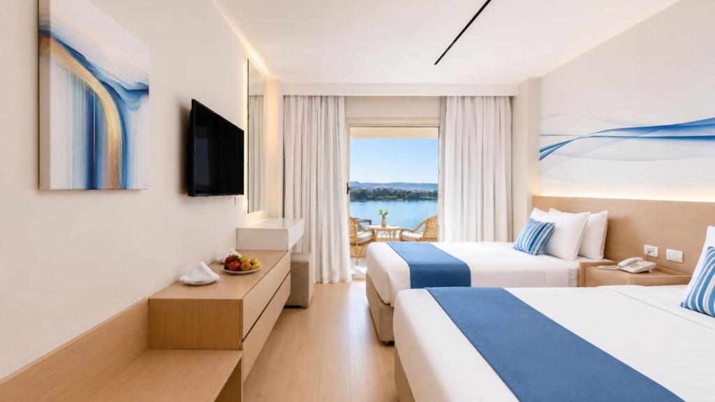 a hotel room with two beds and a window at Obelisk Nile Towers in Aswan