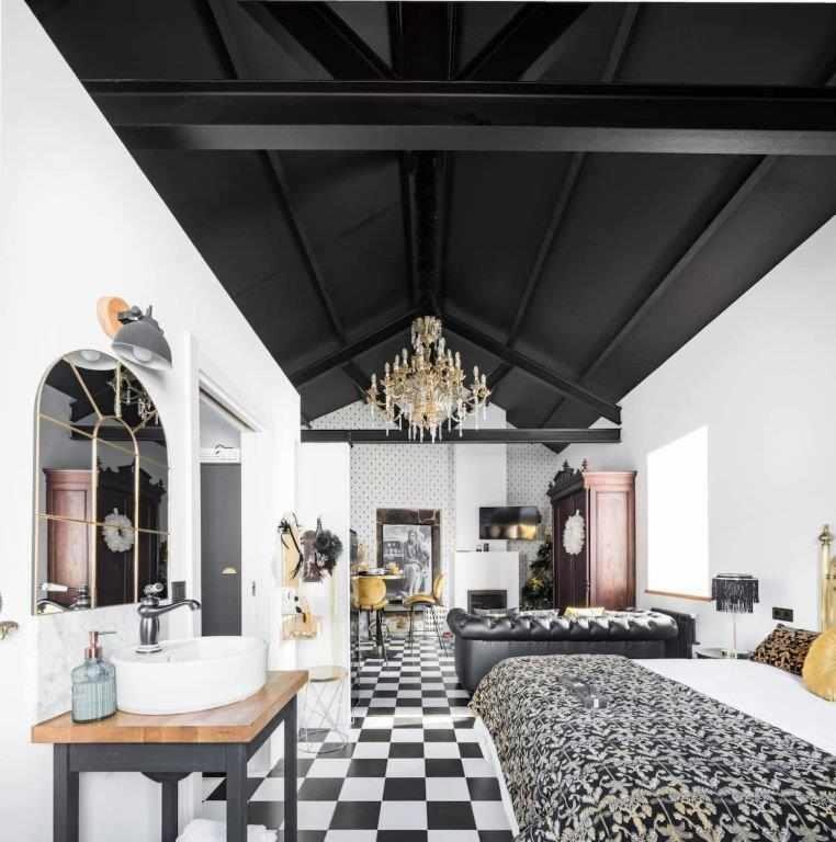 a bedroom with a large bed and a bathroom with a tub at La Suite Años 20. Bañera, chimenea y terraza. in Corcubión