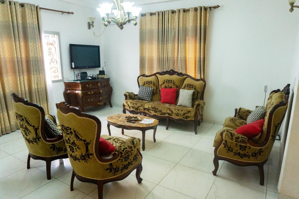 a living room with chairs and a couch and a tv at Résidence Jeanne à Yaoundé Odza Messamengo in Yaoundé