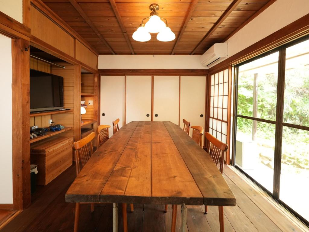 a conference room with a wooden table and chairs at Ukiwa Guest House in Shimoda