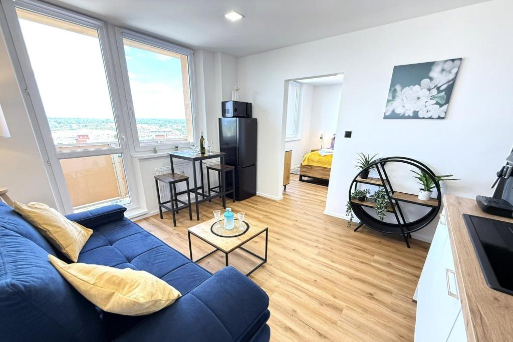 a living room with a blue couch and a table at Sky View Apartmán 10 patro in Břeclav