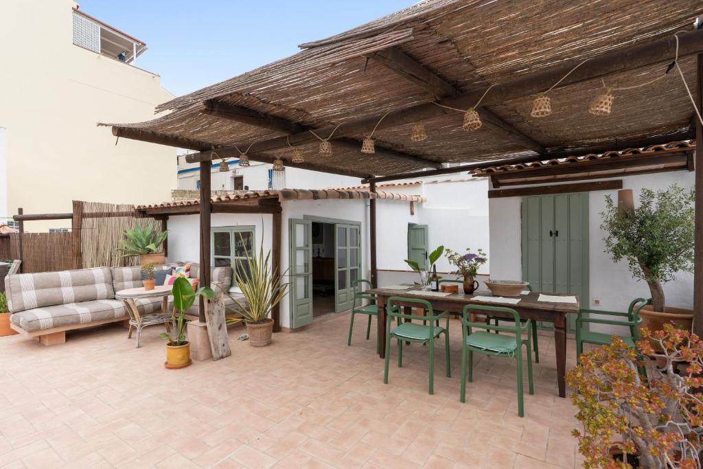 a patio with a wooden pergola and a table and chairs at Casa Terraza in La Herradura