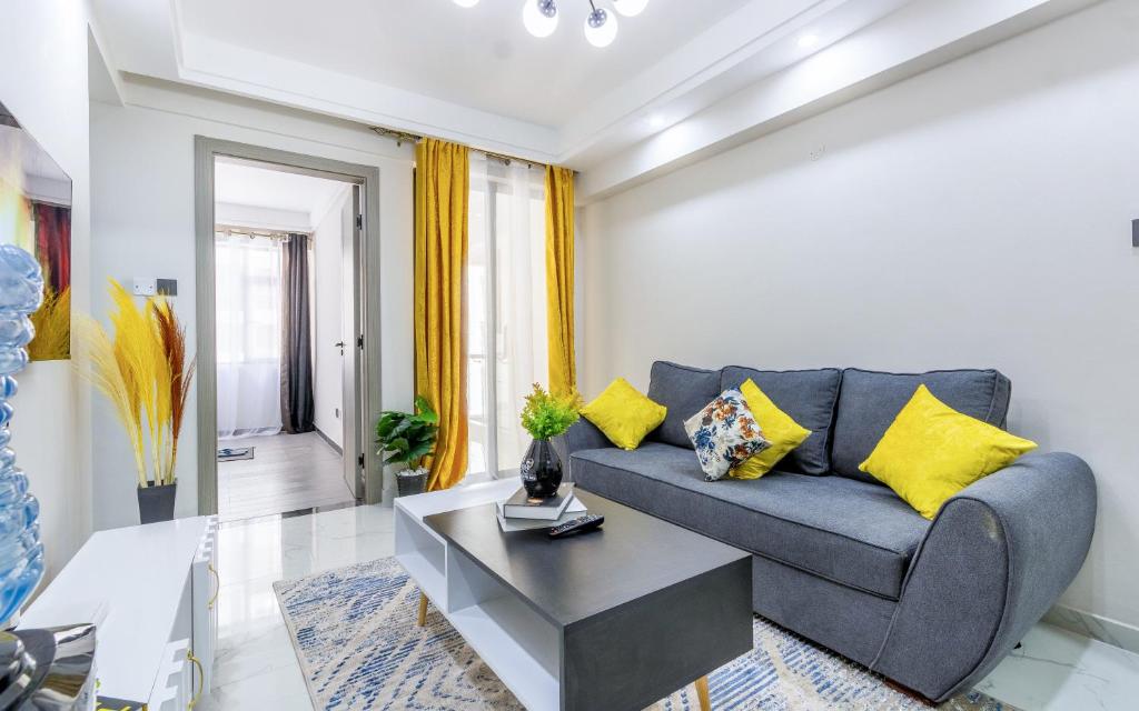 a living room with a blue couch and yellow pillows at Kindaruma Homes Apartments in Nairobi
