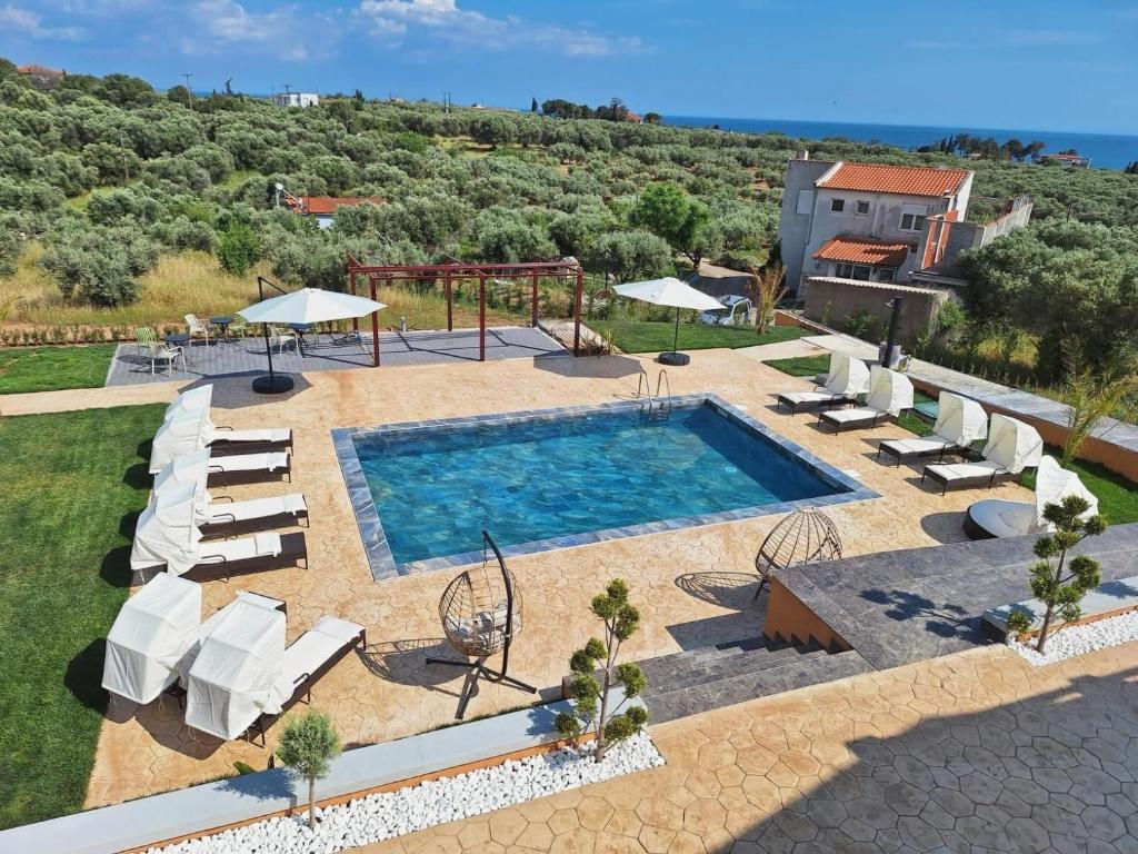 an outdoor swimming pool with chairs and a playground at Resort Finikas in Alexandroupoli