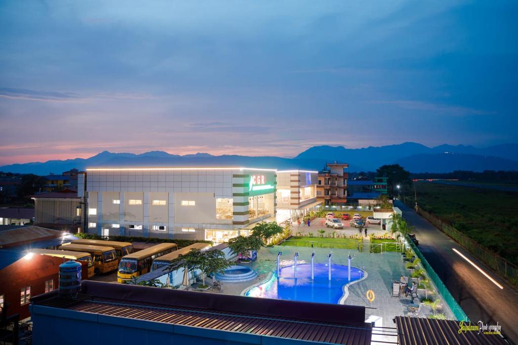 a large building with a pool in front of it at Chitwan Grand Regency in Bharatpur