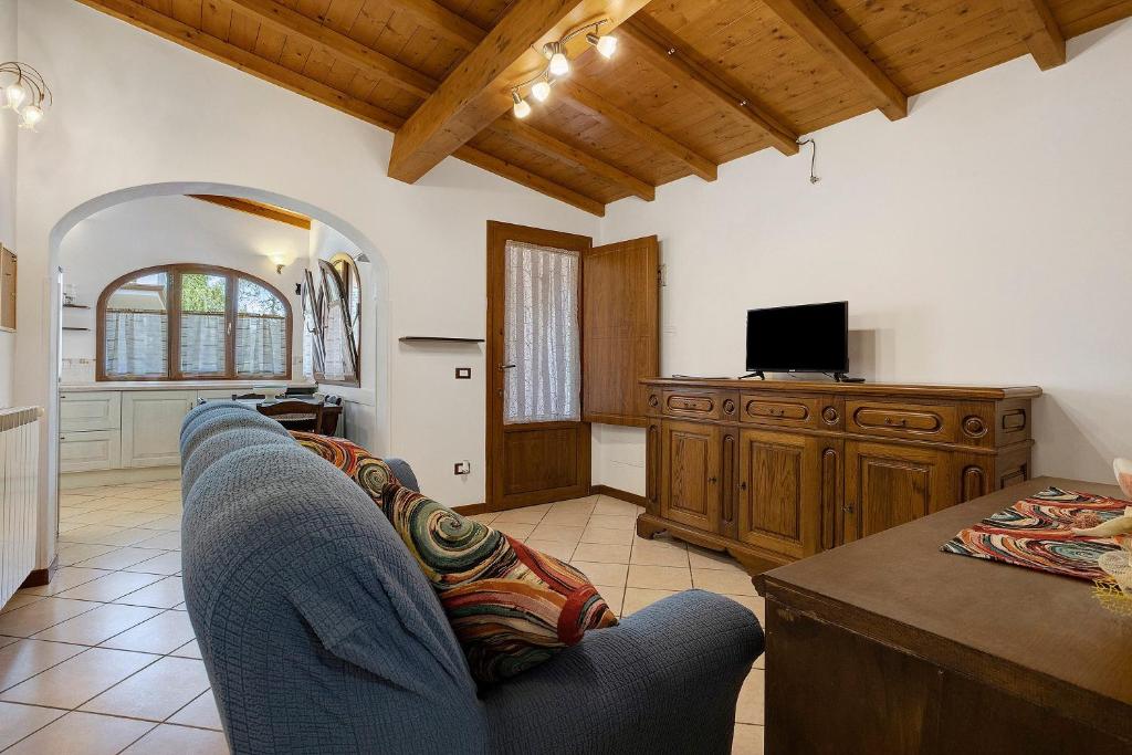 a living room with a blue couch and a tv at I Bibi Vacation Home in Viareggio