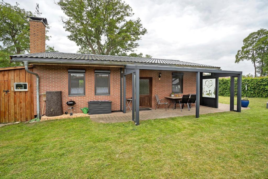 a brick house with a roof and a patio at Ferienhaus Cajo in Dahmen